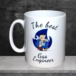 May include: White ceramic mug with a blue and black cartoon illustration of a gas engineer holding a spanner. The text "The best Gas Engineer" is printed on the mug.