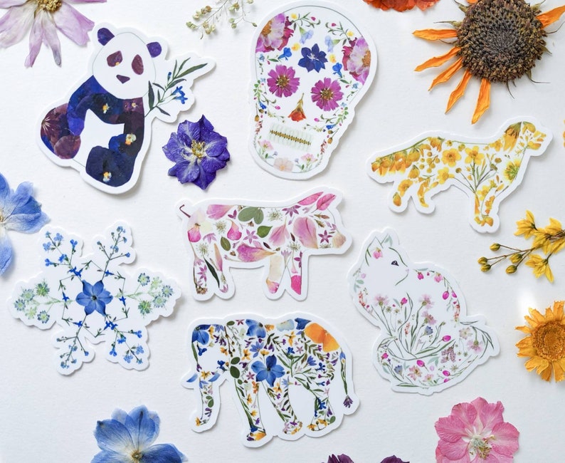 Puede incluir: Un conjunto de pegatinas de flores coloridas con un panda, una calavera, un cerdo, un zorro, un elefante y un gato. Las pegatinas est&aacute;n hechas de flores prensadas y son perfectas para agregar un toque de naturaleza a tus manualidades.