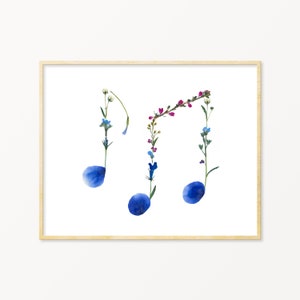 May include: A framed art print featuring a musical note design made from pressed flowers. The notes are blue, with pink, white, and blue flowers forming the stems.