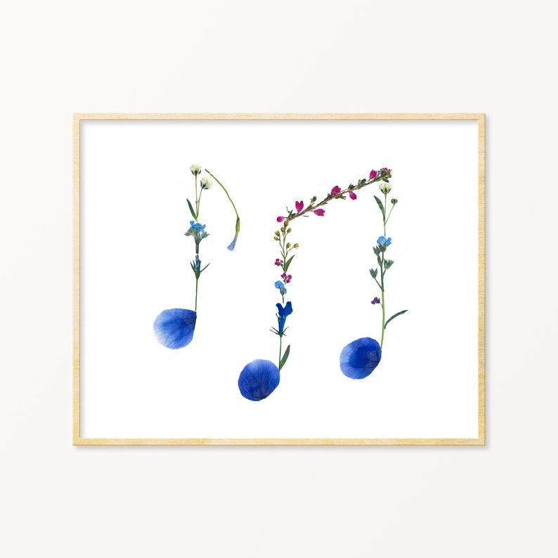 May include: A framed art print featuring a musical note design made from pressed flowers. The notes are blue, with pink, white, and blue flowers forming the stems.