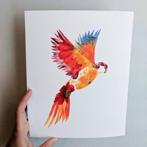 May include: A colorful bird made from pressed flowers. The bird is in flight with its wings spread wide. The bird is made from red, orange, yellow, and blue flowers.