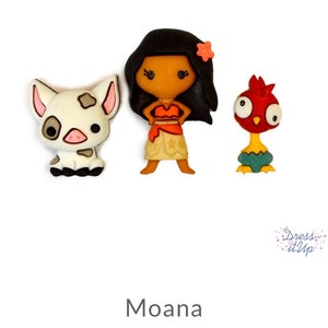 Peut inclure: Trois boutons en feutre représentant les personnages de Moana, Pua le cochon et Hei Hei le coq. Les boutons sont colorés et présentent des motifs de style dessin animé.