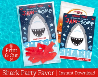 May include: Printable shark party favor tag with the text "Thank you! For making my party Jaw-some" and a cartoon shark with a toothy grin. The tag is in a clear plastic bag with red gummy sharks.