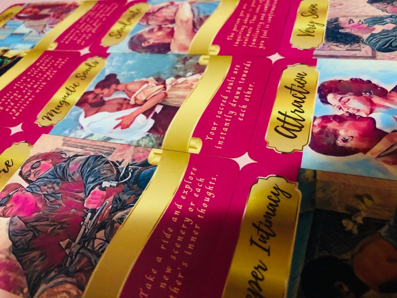 May include: A set of pink and gold tarot cards with romantic illustrations and text. The cards display images of couples and phrases such as "Soulmate," "Attraction," and "Magnetic Souls."