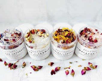 Könnte beinhalten: Vier Glasbehälter gefüllt mit Badesalz und getrockneten Blumen. Die Behälter sind mit den Namen der Düfte beschriftet: Eukalyptus Lavendel, Rose Jasmin, Rosmarin Lavendel und Himalaya-Rosa.