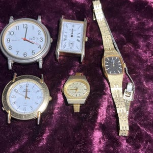 Può includere: Una collezione di cinque orologi da polso vintage. Gli orologi presentano quadranti rotondi e rettangolari con vari design e cinturini in metallo. I colori includono argento, oro e nero, su uno sfondo viola scuro.