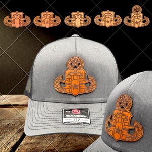 May include: A gray Richardson 112 trucker hat with a brown and orange leather patch featuring a star and a detailed emblem. Several similar patches are displayed above the hat. The hat has a curved brim and a mesh back.