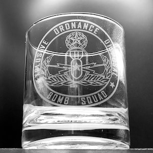 以下が含まれることがあります： 爆発物処理班（EOD）の徽章がエッチングされた透明なガラスのタンブラー。徽章には、翼と稲妻、月桂樹の輪が付いた爆弾が描かれている。徽章の周りに「Ordnance Disposal Bomb Squad」という文字が刻まれている。