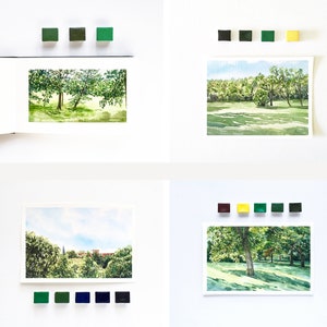 May include: Four watercolor landscape paintings displayed in a grid, each accompanied by small square paint pans in corresponding color palettes. The scenes depict lush green trees, grassy fields, and distant buildings under blue skies.