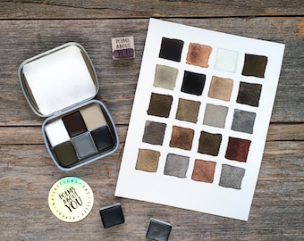 May include: A metal watercolor tin containing six paint pans, a white paper swatch card with twenty-four painted squares in neutral tones, two loose paint pans, a small square stamp reading POEMS ABOUT YOU, and a round sticker with the same text.