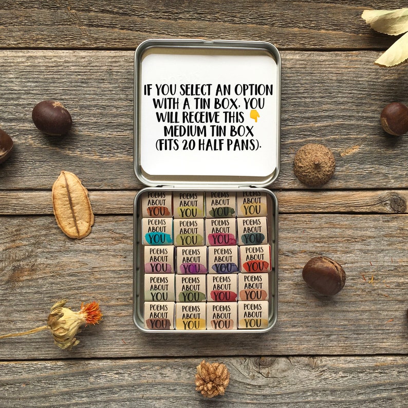 May include: A white tin box with the text "IF YOU SELECT AN OPTION WITH A TIN BOX, YOU WILL RECEIVE THIS MEDIUM TIN BOX (FITS 20 HALF PANS)." The box contains 20 small, colorful, wooden squares with the text "POEMS ABOUT YOU" on each.