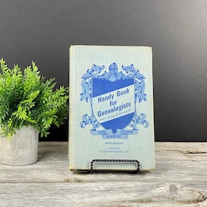 May include: A blue and white book titled "Handy Book for Genealogists" by George B. Everton Sr. The book is a fifth edition and published by The Everton Publishers, Inc. The book cover features a blue shield with a knight in armor and a crown.