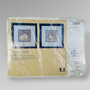 May include: A packaged cross-stitch kit featuring two framed needlepoint pictures of a duck and a bunny. The kit includes cotton/poly net, lace net, and tapestry needle. The package is sealed in clear plastic.