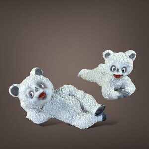 May include: Two white, textured bear figurines with black ears and feet, and red mouths. One bear is lying down, the other is in a playful pose. The bears have a vintage, whimsical aesthetic.