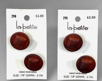 May include: Two cards each with two brown leather buttons. The buttons have a square center and stitched border. The cards read "la-petite", "HAND WASHABLE", and "SIZE: 7/8" (22MM) - 2 ON". Each card has a price tag of $2.00 and the number 298.