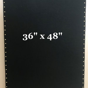 May include: A black rectangular canvas, 36 inches by 48 inches, with a border of small, evenly spaced gold-colored tacks. The dimensions are prominently displayed in white text on the canvas.