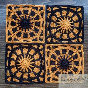 May include: Four crocheted squares in black and yellow with a sunburst design. The squares are arranged in a grid pattern. The text "Rose of May" is in the bottom right corner of the image.
