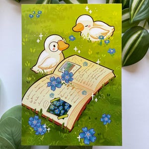 Könnte beinhalten: Illustration mit zwei Enten-Cartoonfiguren in einem grasbewachsenen Feld mit blauen Blumen und einem offenen Buch. Eine Ente trägt eine Brille und betrachtet das Buch mit einem Foto und handschriftlichem Text. Das Buch hat einen roten Einband.