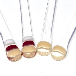 May include: Four clear glass stirring sticks with a red, white and beige stripe pattern at the end.