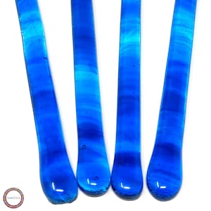 May include: Four blue glass rods with a rounded end. The glass has a swirling pattern.