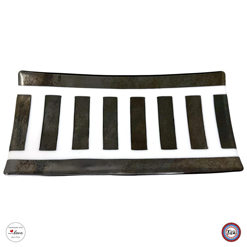 A top-down view of a rectangular glass tray featuring a white background and textured dark metallic vertical bars.