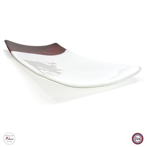 A curved rectangular glass tray rests on a white background, featuring a white main surface and a dark reddish-brown section at one end.