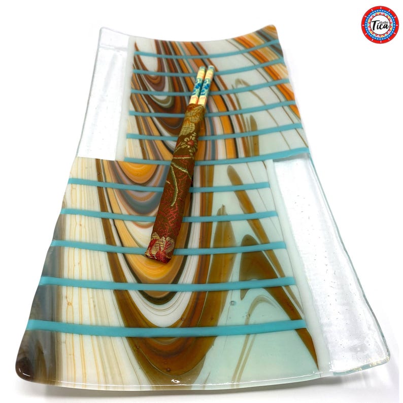 A top-down view of the rectangular glass tray displaying brown, white, and copper swirled stripes with turquoise horizontal bars and chopsticks.