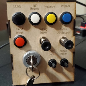 May include: A wooden panel with various switches and buttons, including lights, high beams, hazards, wipers, hand break, parking brake, trailer air supply, diff lock, attach trailer, and ignition. The panel is made of light brown wood and has black and white labels.