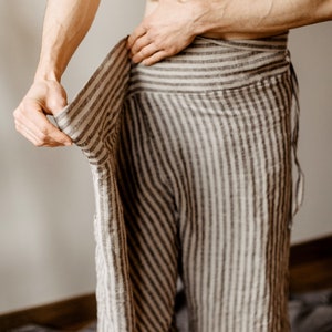 May include: A person wearing a striped linen wrap skirt. The skirt is brown and white with a loose fit.
