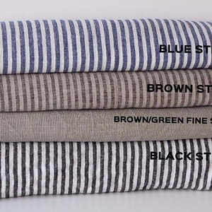 May include: Four different striped fabric swatches stacked on top of each other. The top swatch is blue and white striped, the second swatch is brown and white striped, the third swatch is brown and green striped, and the bottom swatch is black and white striped. The text "BLUE STRIPED", "BROWN STRIPED", "BROWN/GREEN FINE STRIPED", and "BLACK STRIPED" is printed on each swatch.