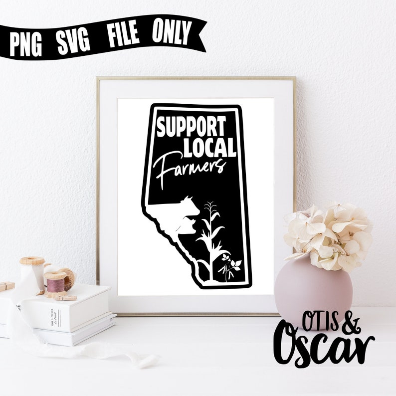 Op de afbeelding: Zwart-wit grafisch ontwerp van een staatsschets met de tekst "Support Local Farmers" erin. De grafiek wordt weergegeven in een wit frame op een wit oppervlak.