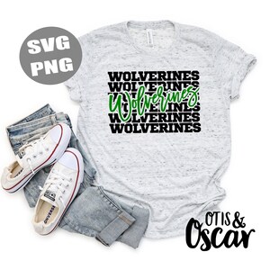 Pu&ograve; includere: Una maglietta bianca con una grafica nera e verde che dice "WOLVERINES" ripetuta cinque volte. La maglietta &egrave; su uno sfondo bianco con un paio di jeans blu e scarpe da ginnastica bianche.