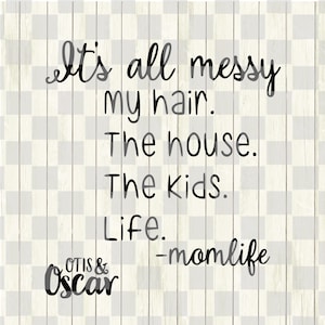 以下が含まれることがあります： 「It's all messy my hair. The house. The kids. Life.」というテキストが黒い筆記体で書かれた装飾的なサイン。サインには「-momlife」というテキストとブランド名「Otis & Oscar」も含まれています。背景は木目模様です。
