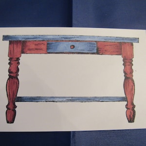 May include: A hand-drawn illustration of a small wooden table with a single drawer. The table is painted in shades of blue and red, with a simple design. The table has four legs and a rectangular top.