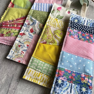 Può includere: Quattro ornamenti appesi in patchwork di tessuto con diversi motivi e colori. Ogni ornamento ha un anello in cima per l'appeso.