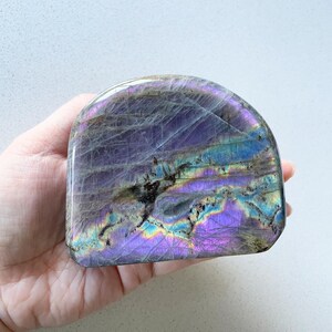 以下が含まれることがあります： 丸みを帯びた半球形の、研磨された虹色のラブラドライトの結晶。結晶は、紫、青、緑など、さまざまな色合いを見せています。