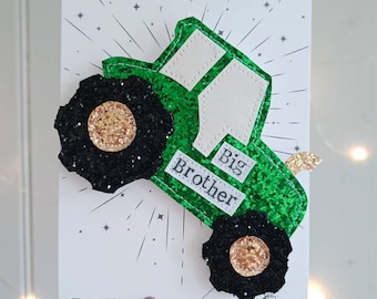 May include: Green glitter tractor with black wheels and gold accents. The tractor has a white label that says "Big Brother".
