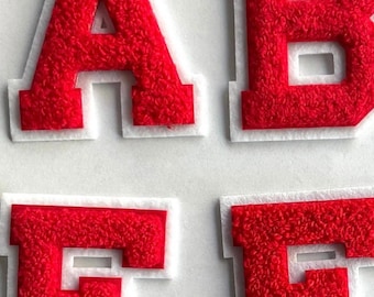 May include: Red felt letters A, B, E, and F with white outlines. The letters are raised and have a fuzzy texture.