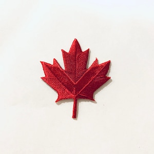 May include: A red felt embroidered Canadian maple leaf patch.