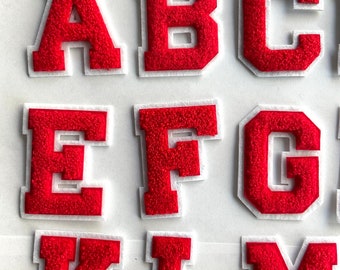 May include: Red felt letters of the alphabet, A, B, C, E, F, G, K, L, and M. The letters are outlined in white.