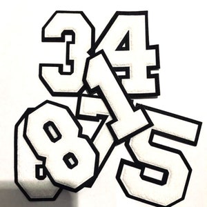 May include: A set of five white felt iron-on numbers with black outlines. The numbers are 3, 4, 1, 8, and 5.