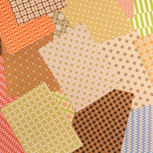 May include: A collection of rectangular paper sheets featuring various retro-inspired patterns, including geometric grids, small floral motifs, starbursts, and wavy lines in a palette of orange, brown, cream, yellow, green, and light blue.