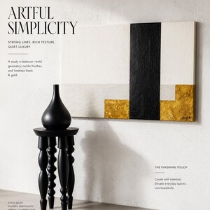 May include: A black vase sits atop a black, decorative side table with turned legs. A modern abstract painting with black, white, and gold geometric shapes hangs on the wall. The text reads "ARTFUL SIMPLICITY".