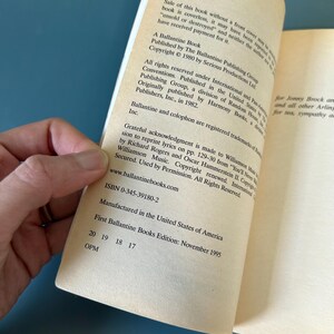 May include: An open book showing text from a Ballantine Book. The text includes copyright details, ISBN, and the edition date of November 1995. The book is open, revealing the inside pages.