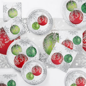 May include: A set of Christmas party supplies featuring red and green ornaments with silver glitter on a white background with snowflakes. The set includes plates, napkins, and a table cover.