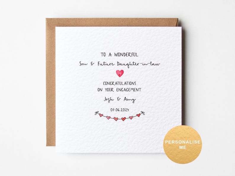 May include: A white card with a brown envelope. The card has a red heart and the text "To a wonderful Son & Future Daughter-in-law Congratulations on your engagement Josh & Amy 07.06.2024".