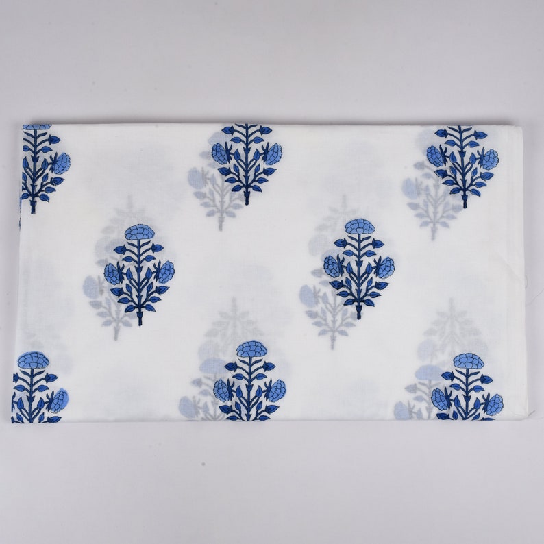White cotton fabric with a blue floral print. The fabric is folded in half and the floral pattern is visible on both sides.