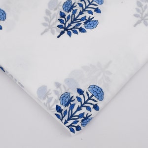Puede incluir: Tela blanca con estampado floral azul. La tela presenta un patr&oacute;n repetitivo de flores y hojas azules sobre un fondo blanco.