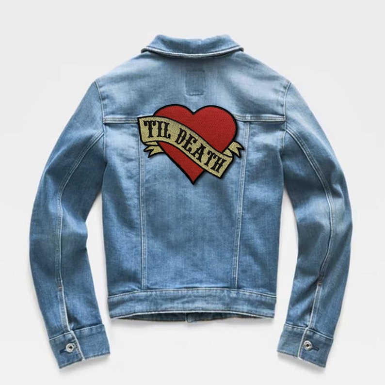 May include: A blue denim jacket with a red heart and a gold banner that says "Til Death" on the back.