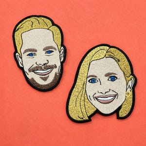 Könnte beinhalten: Zwei gestickte Aufnäher mit stilisierten Porträts von zwei Personen. Ein Aufnäher zeigt eine Person mit kurzem blonden Haar, blauen Augen und braunem Bart. Der andere zeigt eine Person mit schulterlangem blonden Haar, blauen Augen und einem kleinen goldenen Ohrring.